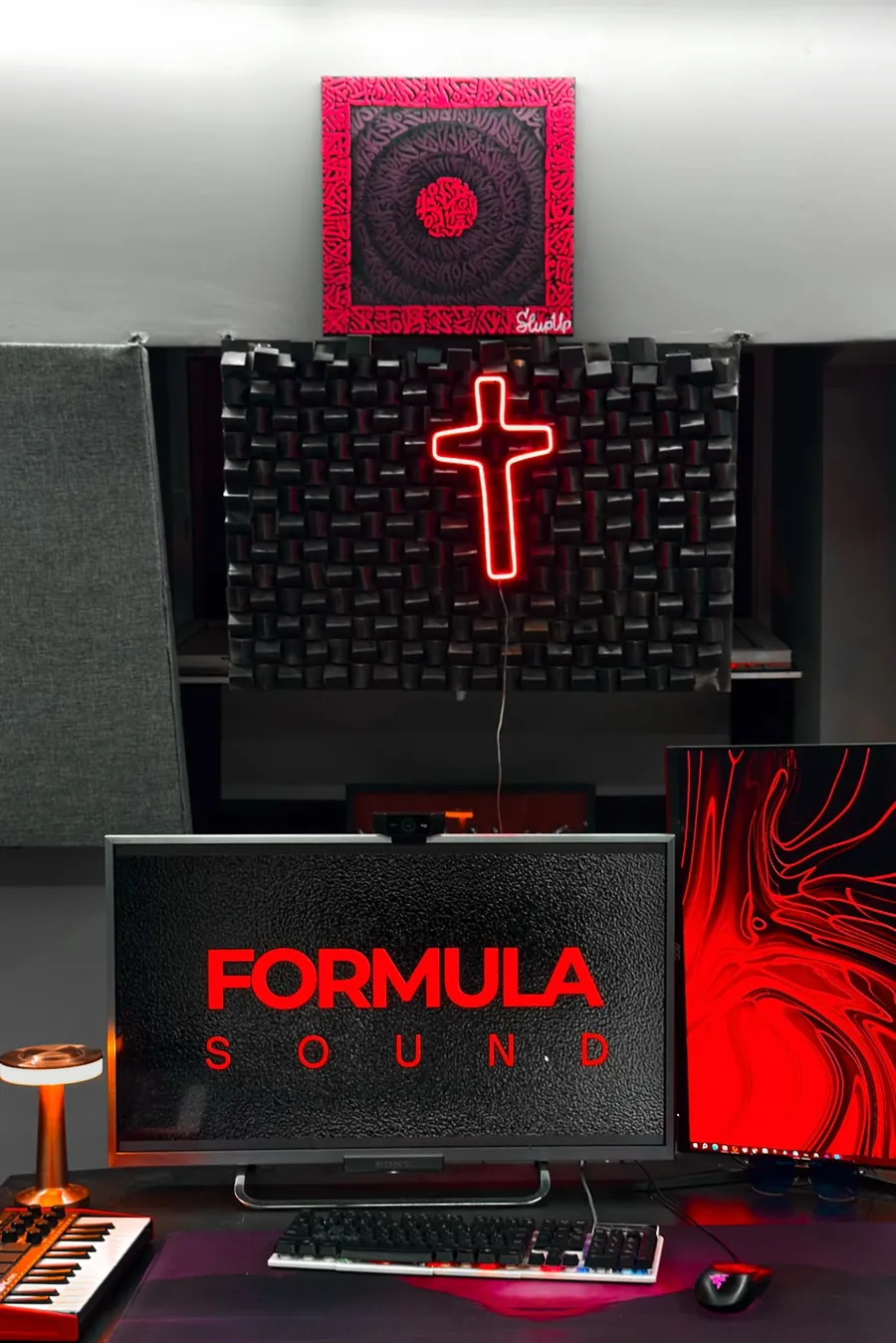 Неоновый крест над рабочим местом и экран с логотипом Formula Sound